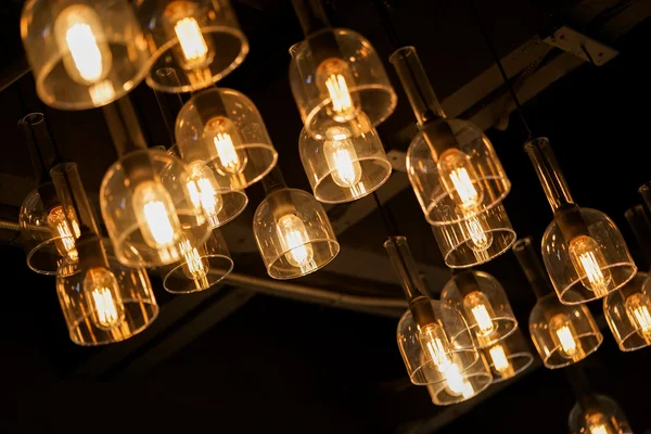 Vintage hanging light bulbs on dark background — Stock Photo, Image