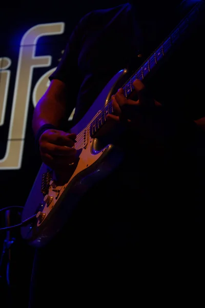 발자국을 표시하는 기타를 연주하고 파란색 조명을 가지고 연주하는 연주자들의 — 스톡 사진