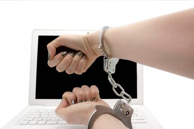 Krom gümüşten cilalı kadın bebekler. Siber suç kavramsal dizüstü bilgisayarının önünde kelepçeli olanlar.