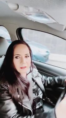 Modern kadın memnun edici arabasıyla gün batımında hareket eden şafak kamerası.