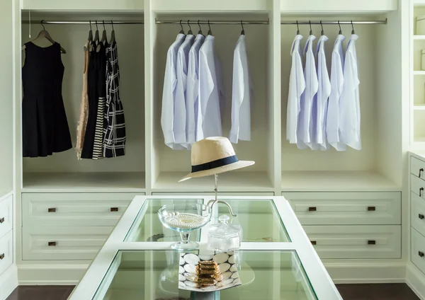 Sombrero blanco y joyas colocadas en una mesa de tocador en un vestidor — Foto de Stock