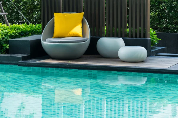 Relaxing chairs with pillows beside swimming pool — Stock Photo, Image