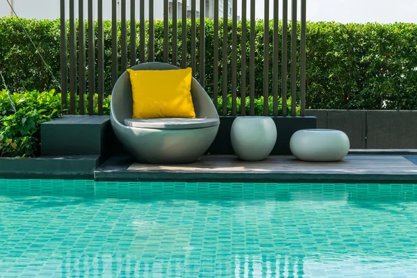 Cadeiras relaxantes com almofadas ao lado da piscina — Fotografia de Stock