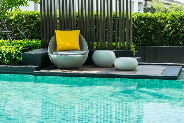 Relaxing chairs with pillows beside swimming pool — Stock Photo, Image