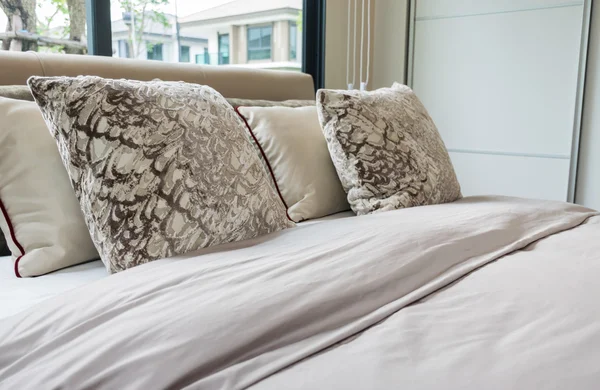 Сучасний дизайн спальні з ліжком, подушками і лампою на столі — стокове фото