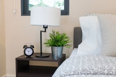 close up of bedroom with reading lamp and alarm clock clipart