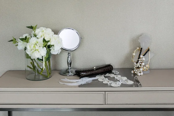 Beauty and make-up concept: mirror,jewelry and makeup set on a table