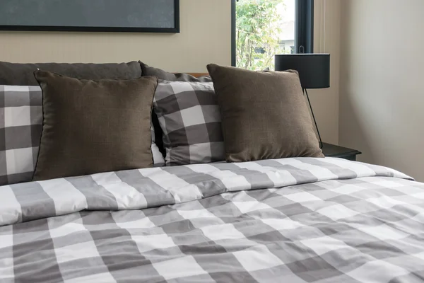 Кровать и коричневые подушки в современной спальне — стоковое фото