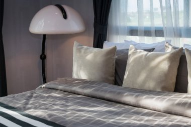 yastıklar ve beyaz lamba ile modern yatak odası