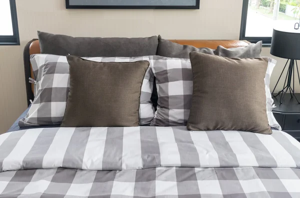 Κρεβάτι και καφέ μαξιλάρια σε σύγχρονη κρεβατοκάμαρα — Φωτογραφία Αρχείου