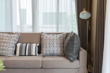 Gri desenli yastıklar ile sağlam kahverengi tüvit kanepe