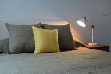 Yastıklar ve okuma lâmbası başucundaki ile rahat yatak odası iç