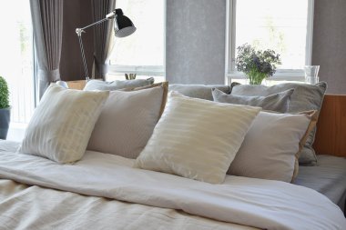 Beyaz çizgili yastık yatak ile şık yatak odası iç tasarım