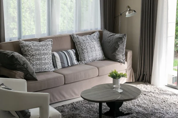 Solidne brązowe tweed sofa z szarym wzorzyste poduszki — Zdjęcie stockowe