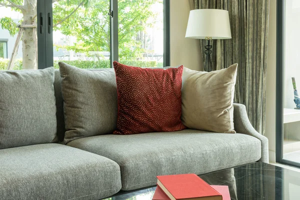 Moderne dagligstuedesign med røde puter på sofa og lampe – stockfoto