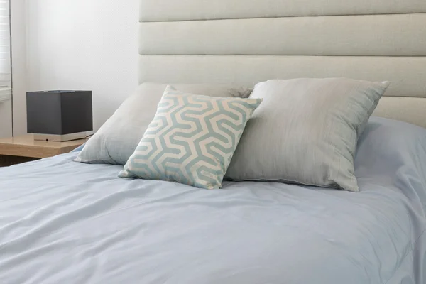 Travesseiros macios confortáveis na cama azul clara — Fotografia de Stock