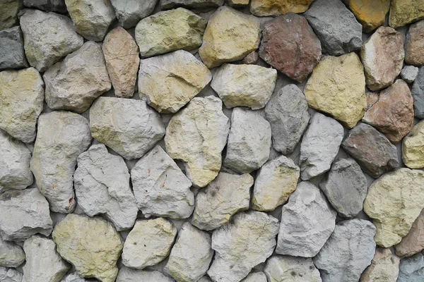 Amarillo, rojo, azul, piedras y guijarros en la pared gris, fondo , — Foto de Stock