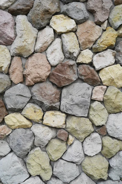 Amarillo, rojo, azul, piedras y guijarros en la pared gris, fondo , — Foto de Stock