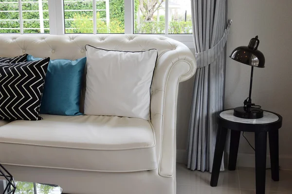 在老式的客厅里的白色皮沙发上的白色和蓝色的枕头 — 图库照片
