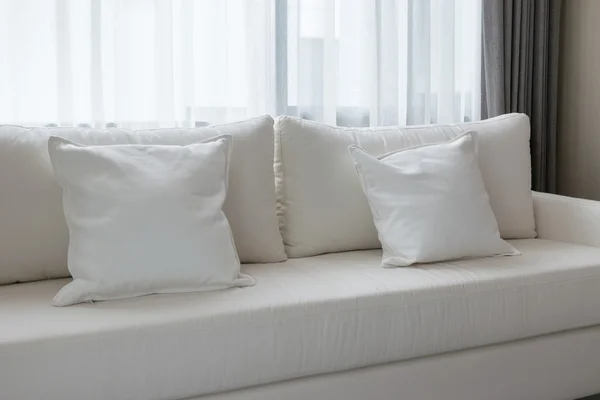 Almohadas decorativas blancas en un sofá informal en la sala de estar — Foto de Stock