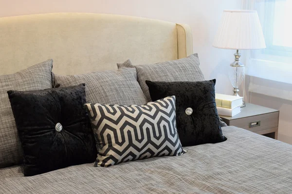 Elegante dormitorio de diseño interior con almohadas con dibujos negros en la cama y lámpara de mesa decorativa . — Foto de Stock