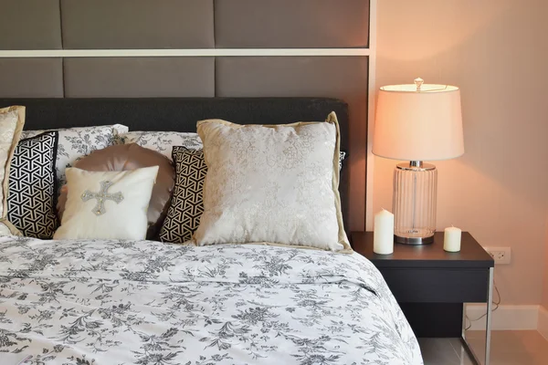 Роскошный интерьер спальни с цветочным узором подушки и декоративные настольные лампы — стоковое фото