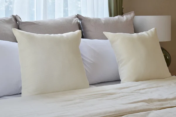 Дизайн інтер'єру спальні з білими подушками на ліжку і декоративна настільна лампа . — стокове фото