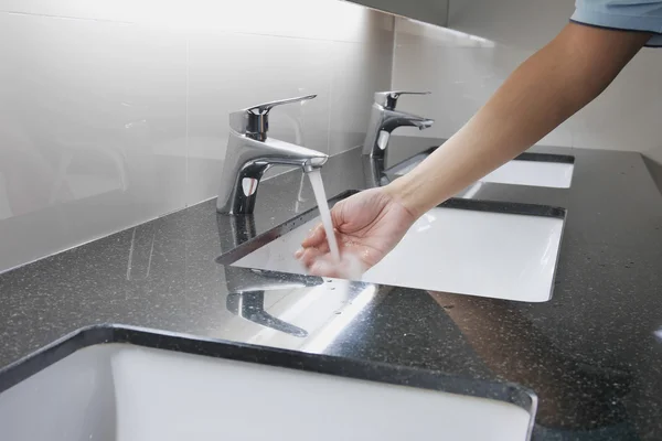 Vitt handfat och kran på granit räknare med handtvätt — Stockfoto