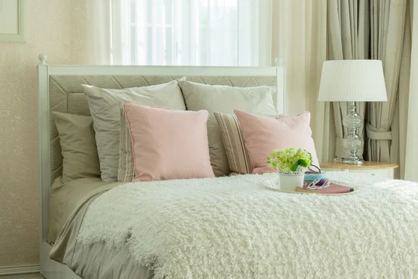 Interior do quarto de luxo com travesseiros rosa e bandeja branca de flor na cama — Fotografia de Stock