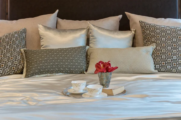 lüks yatak odası iç kahverengi deseni yastık ve dekoratif çiçek yatakta