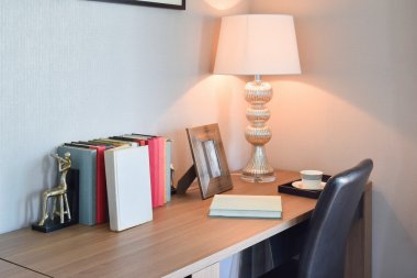ahşap masa lambası ve modern çalışma odasında kitap okuma ile