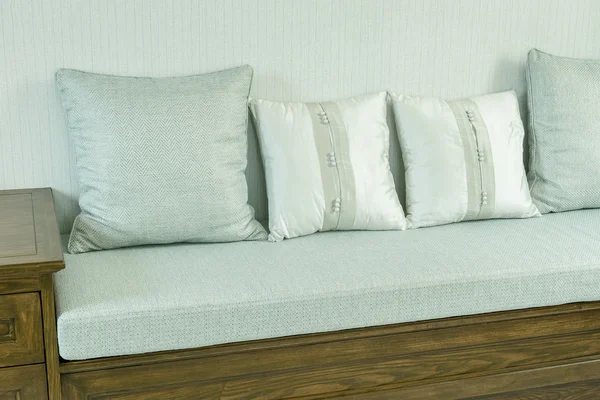 Salón interior con almohadas blancas y grises en sofá de madera — Foto de Stock