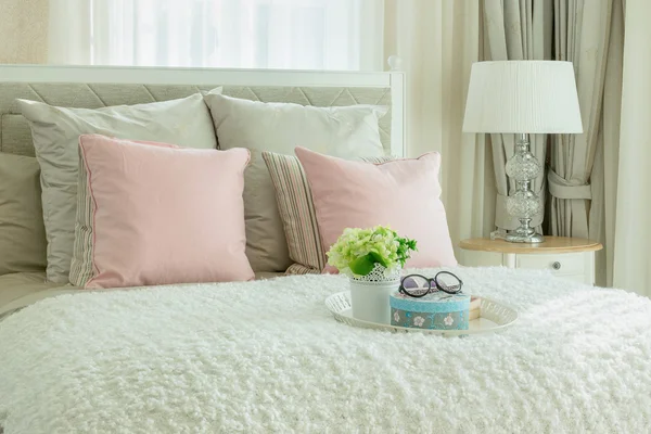 Aconchegante interior do quarto com travesseiros rosa e bandeja branca de flor — Fotografia de Stock