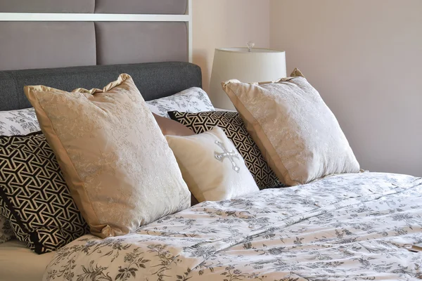 Розкішний інтер'єр спальні з подушками з квіткового візерунка та декоративною настільною лампою — стокове фото