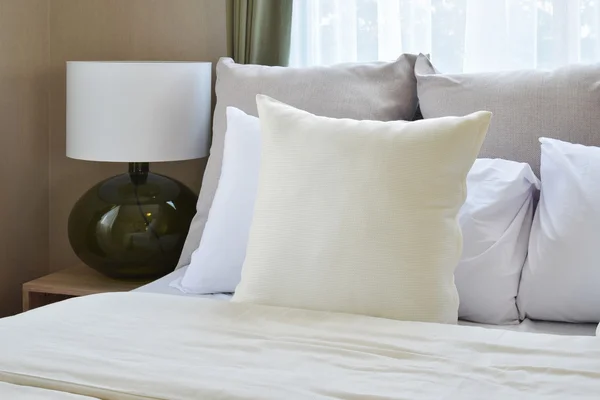 Υπνοδωμάτιο διακόσμηση με λευκά μαξιλάρια στο κρεβάτι και του διακοσμητικού επιτραπέζιου λαμπτήρα. — Φωτογραφία Αρχείου