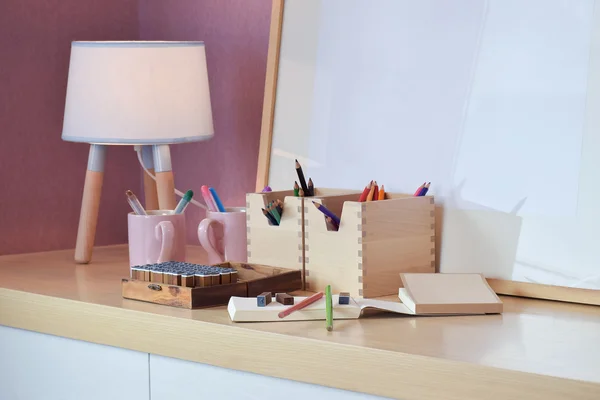 Набор цветных карандашей и резиновых штампов с ноутбуком на деревянном столе — стоковое фото