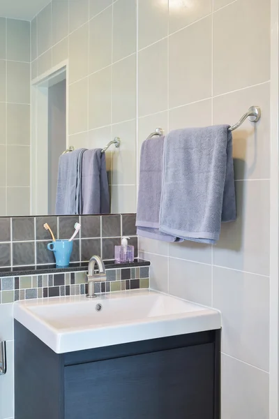 Toallero junto al lavabo con pastas dentales en decorativo moderno — Foto de Stock