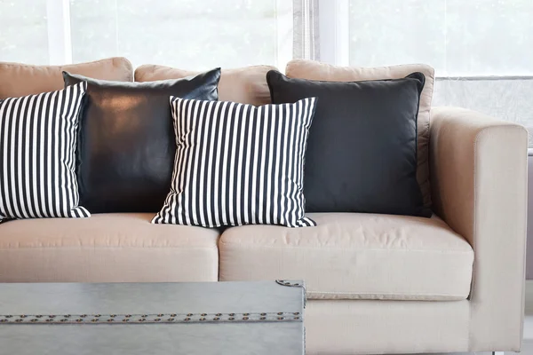 Almohadas de cuero rayas y negras en terciopelo sofá beige en el moderno salón de estilo industrial — Foto de Stock