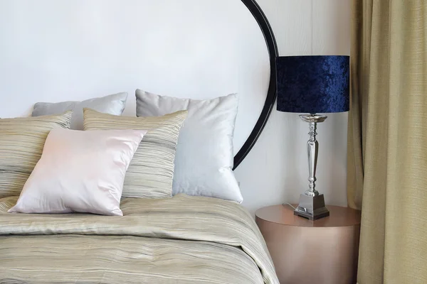 Стильный дизайн интерьера спальни с подушками на кровати и декоративной настольной лампой . — стоковое фото