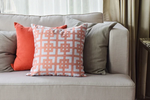 Patrón chino en naranja y naranja profundo y almohadas grises en juego de sofá gris claro — Foto de Stock