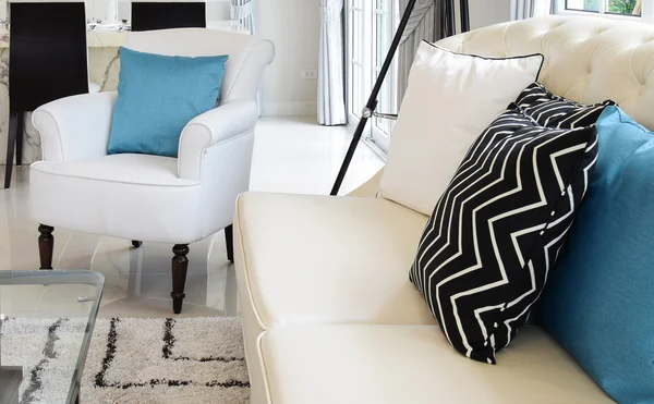 Almohadas blancas y azules en un sofá de cuero blanco en la sala de estar vintage — Foto de Stock