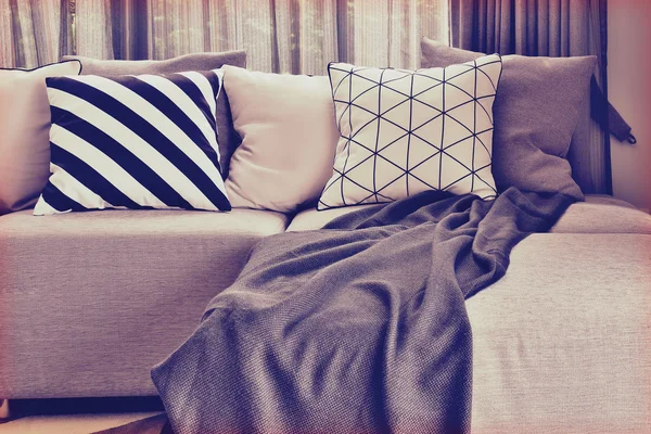 与光灰色 L 形沙发不同图案和色彩的枕头，在生活的角落里 — 图库照片