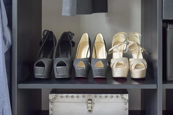 Ряд женской обуви на черной деревянной полке — стоковое фото