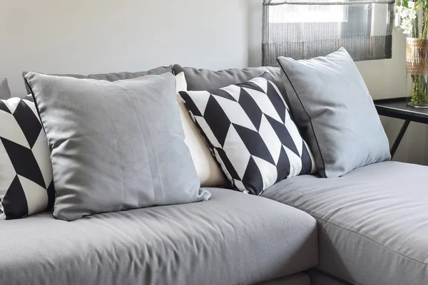 Almohadas patrón paralelogramo blanco y negro en forma de l gris cómodo sofá — Foto de Stock