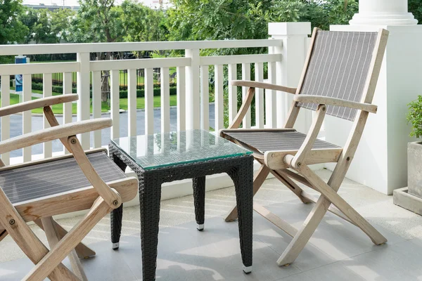 Houten stoelen op moderne balkon met uitzicht op een tuin — Stockfoto