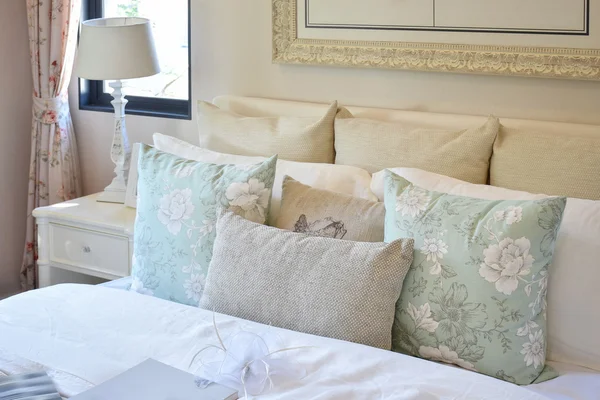 Chambre vintage intérieur avec oreiller motif fleur et lampe de lecture sur table de chevet blanche — Photo
