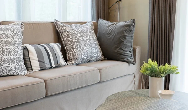 Міцний коричневий твістний диван з сірими візерунчастими подушками — стокове фото