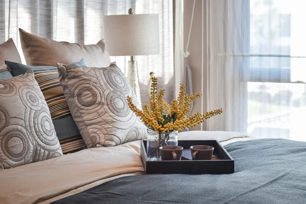 Розкішний дизайн інтер'єру спальні з декоративним чайним набором і смугастими подушками на ліжку — стокове фото