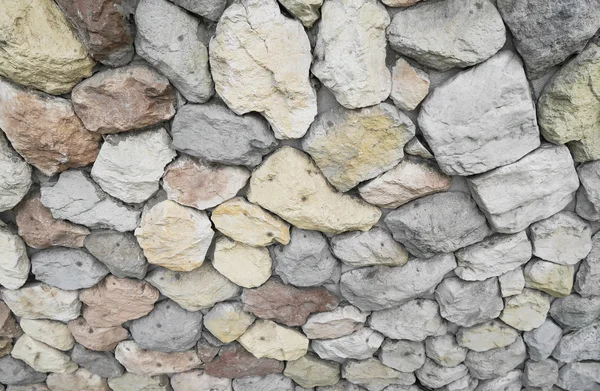 Amarillo, rojo, azul, piedras y guijarros en la pared gris, fondo , — Foto de Stock