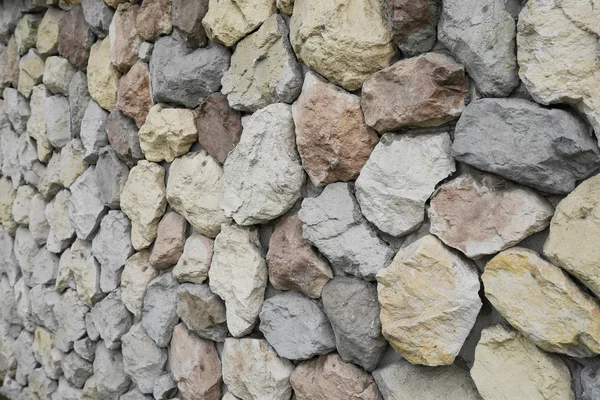 Amarillo, rojo, azul, piedras y guijarros en la pared gris, fondo , — Foto de Stock